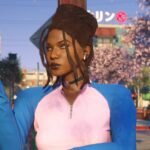 An image of a black woman with dreadlocks and a pink and blue zip up top standing in front of cherry blossoms and a building with a Japanese sign