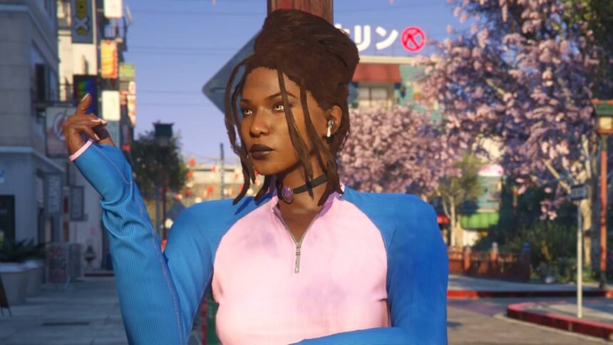 An image of a black woman with dreadlocks and a pink and blue zip up top standing in front of cherry blossoms and a building with a Japanese sign