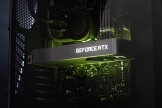 Closeup of a dark grey graphics card with white 'GeForce RTX' backlighting within a PC build