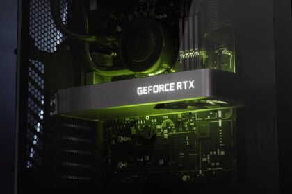 Closeup of a dark grey graphics card with white 'GeForce RTX' backlighting within a PC build