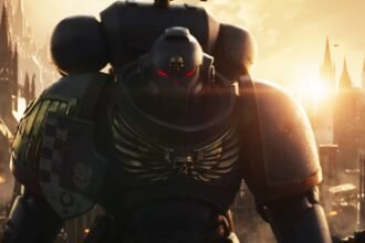 The Emperor would approve of Total War Warhammer 40k, Creative Assembly says. I can't help but agree.: An image of a Space Marine from Total War: Warhammer 40k standing in front of a sunset with cathedral-like buildings