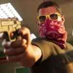 GTA 6 weapons: a man wearing a red bandana over his mouth and yellow sunglasses points a gun at another person off-screen.
